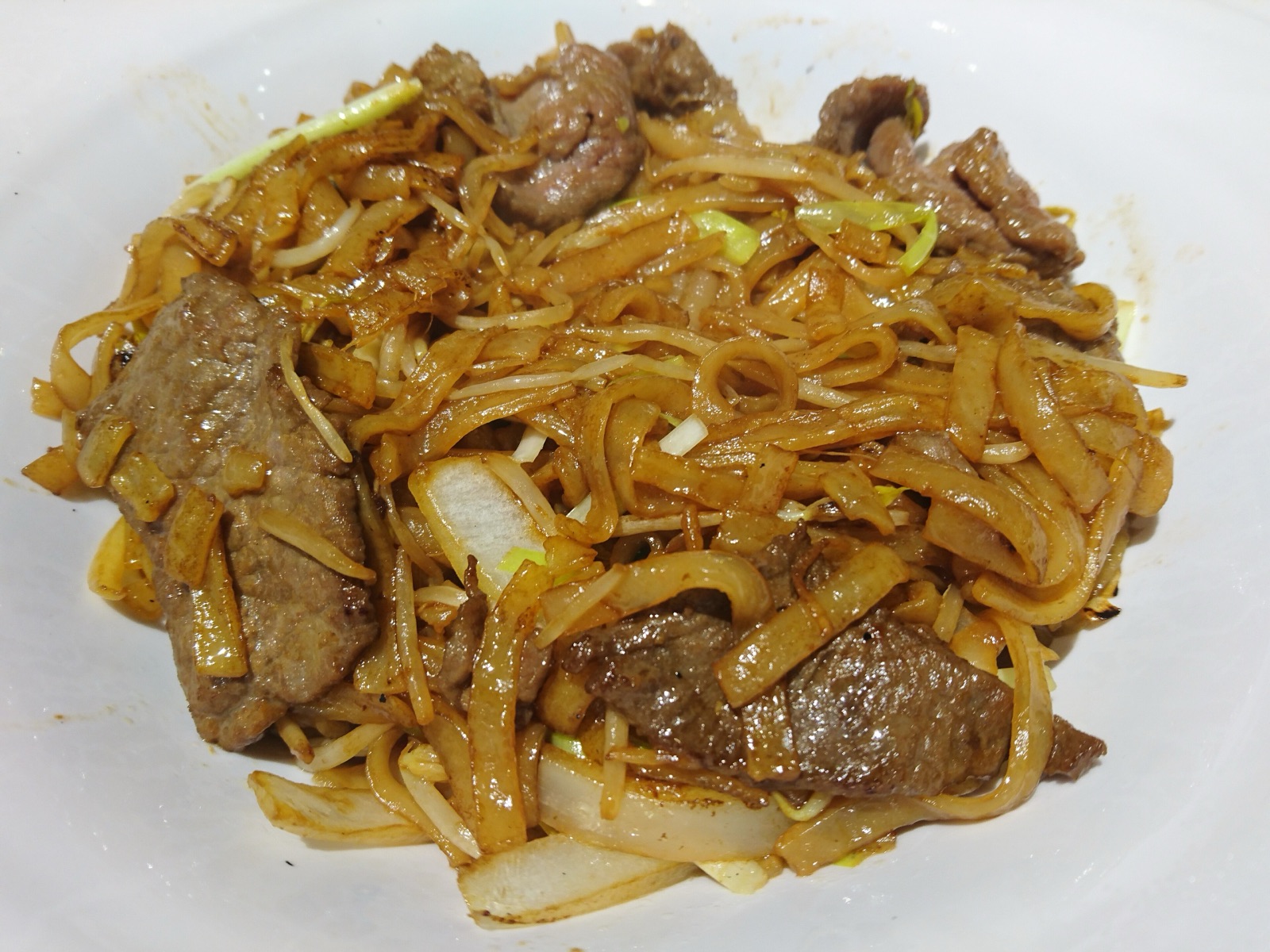 Overhead view of beef chow fun with bean sprouts, onion and browned beef