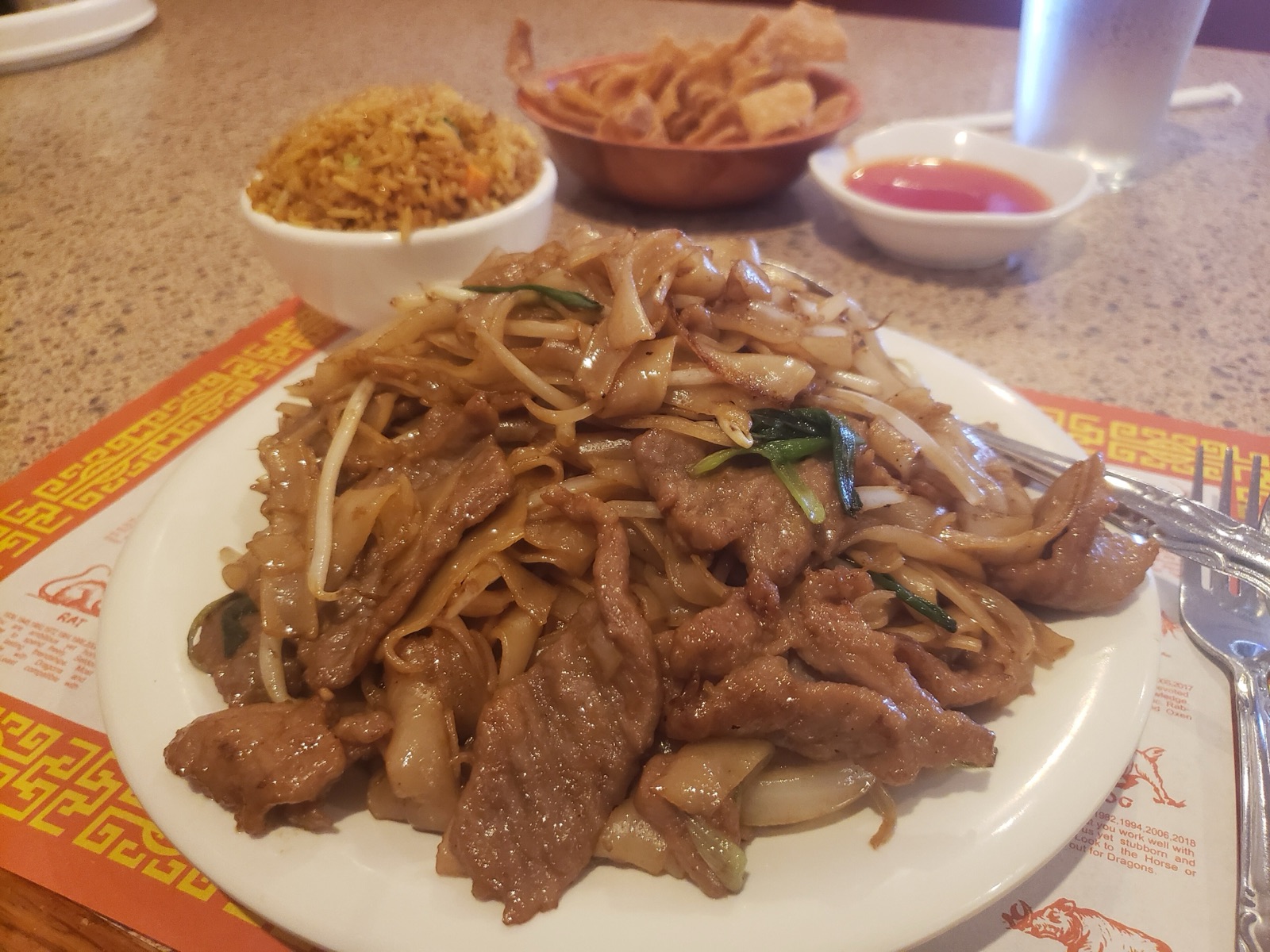 A generous plate of beef chow fun with fried rice and a bowl of crispy noodles